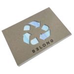 A recycled notebook with a cut-out design, featuring blue and white patterns and a branding logo.