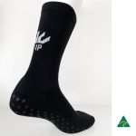 A black sock with a ribbed design and textured grip dots on the sole. It features a logo on the side.