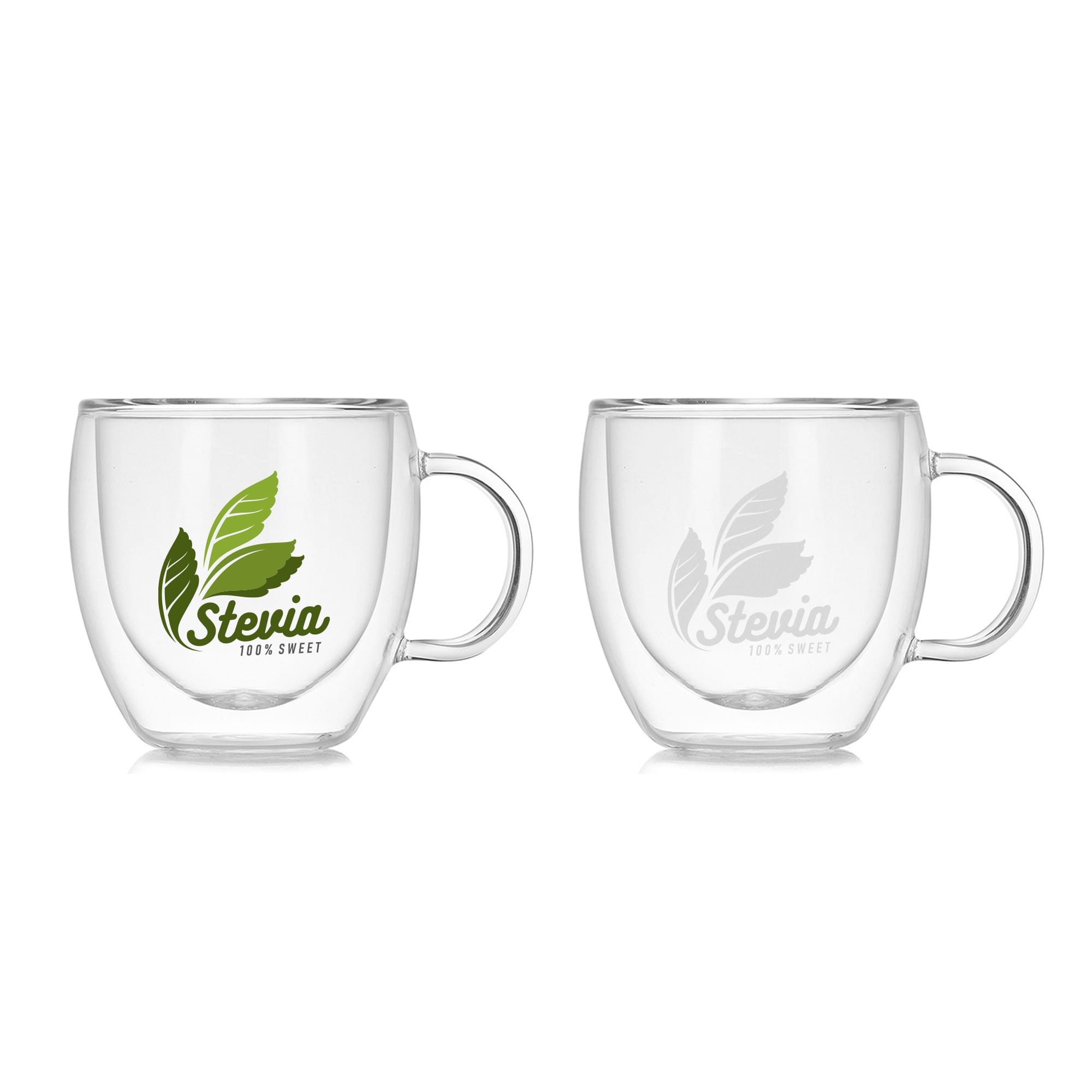 A double wall glass mug in clear, featuring a handle and a logo with green leaves. Two mugs are displayed side by side. Classic Double Wall Mug - Image 1