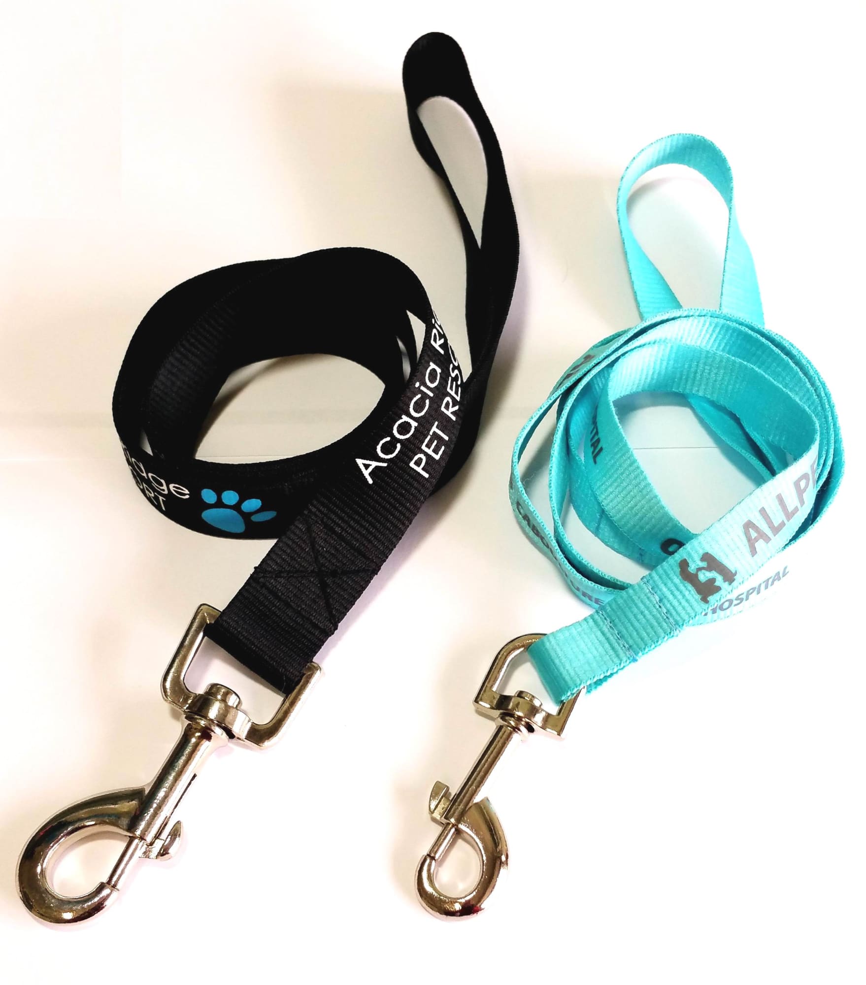 Two dog leads, one black and one light blue, each with metal clips for attachment. Both leads have logos. Dog Leads 15mm - Image 1