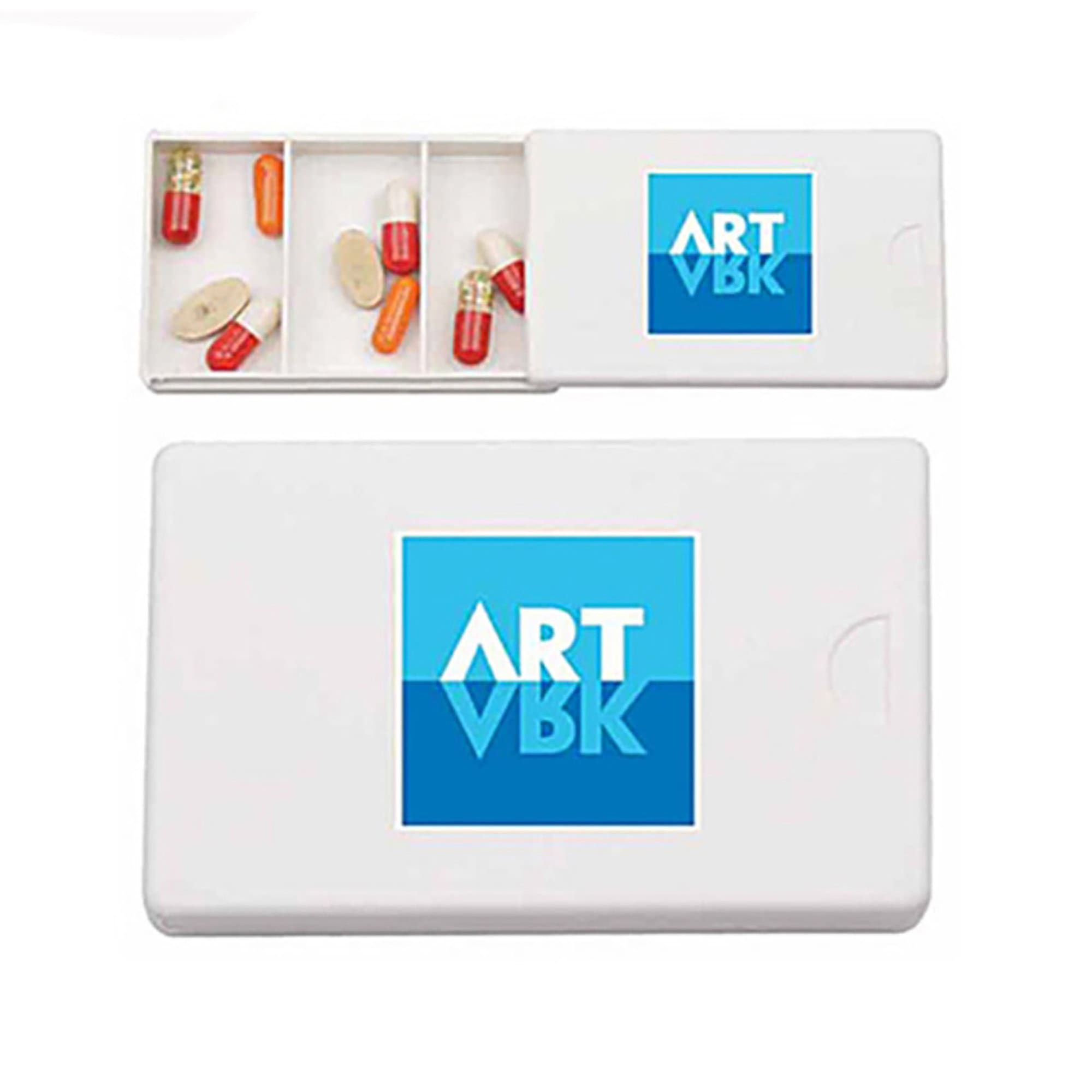 A white pill box with compartments containing various capsules, featuring a logo on the lid. Pill Box - Image 1