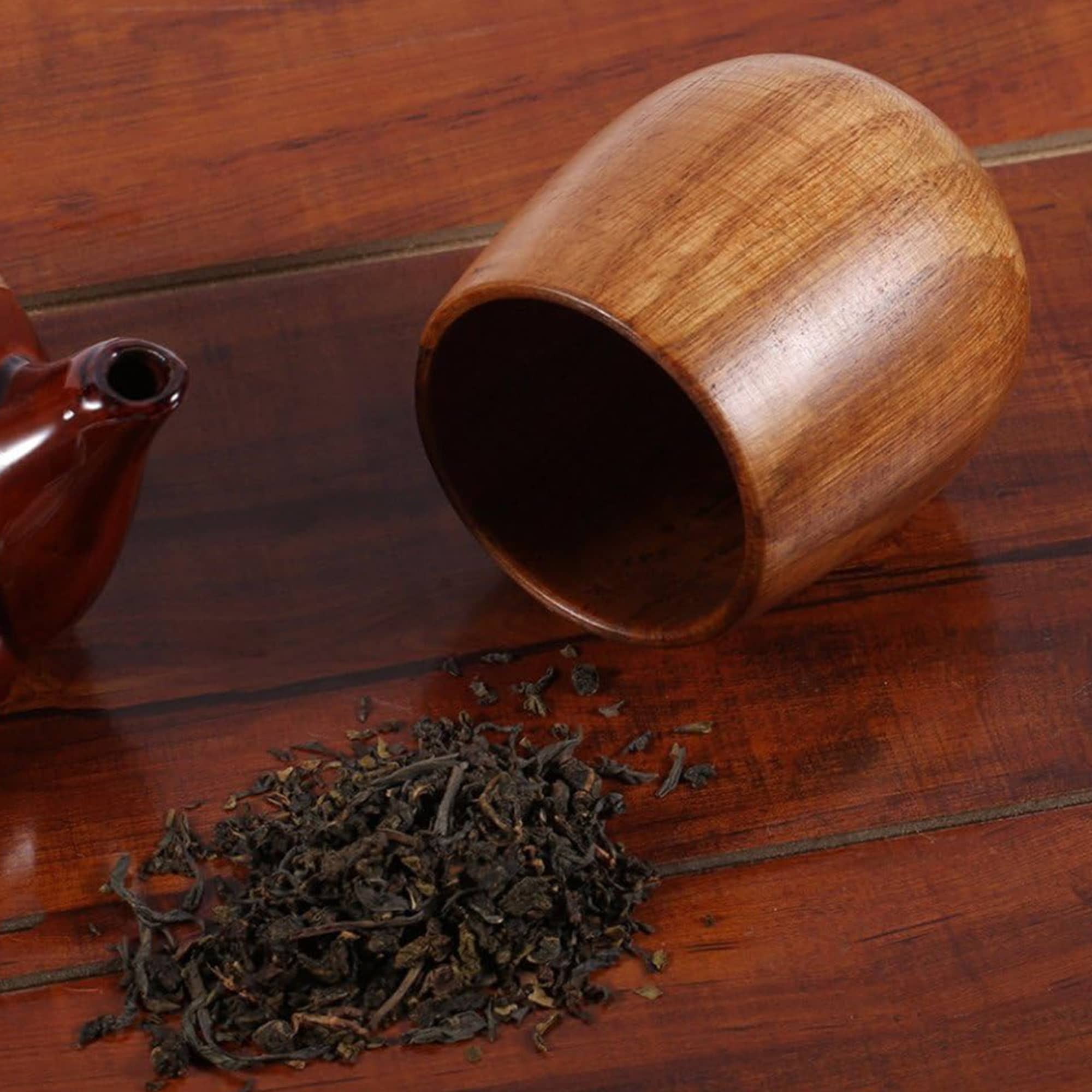 A small wooden coffee cup in a rich brown hue, beside loose tea leaves and a teapot. Small Wooden Coffee Cup - Image 1