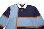 A sports jumper featuring navy, light blue, and brown colours, with a white collar and a logo.
