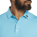 A men's polo shirt in light blue featuring a tonal dot print and a logo on the collar.