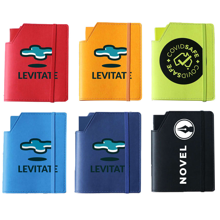 A collection of six leatherette notebooks in various colours: orange, green, blue, and black, each with a logo. Leatherette Large Cover & Notebook - Image 1