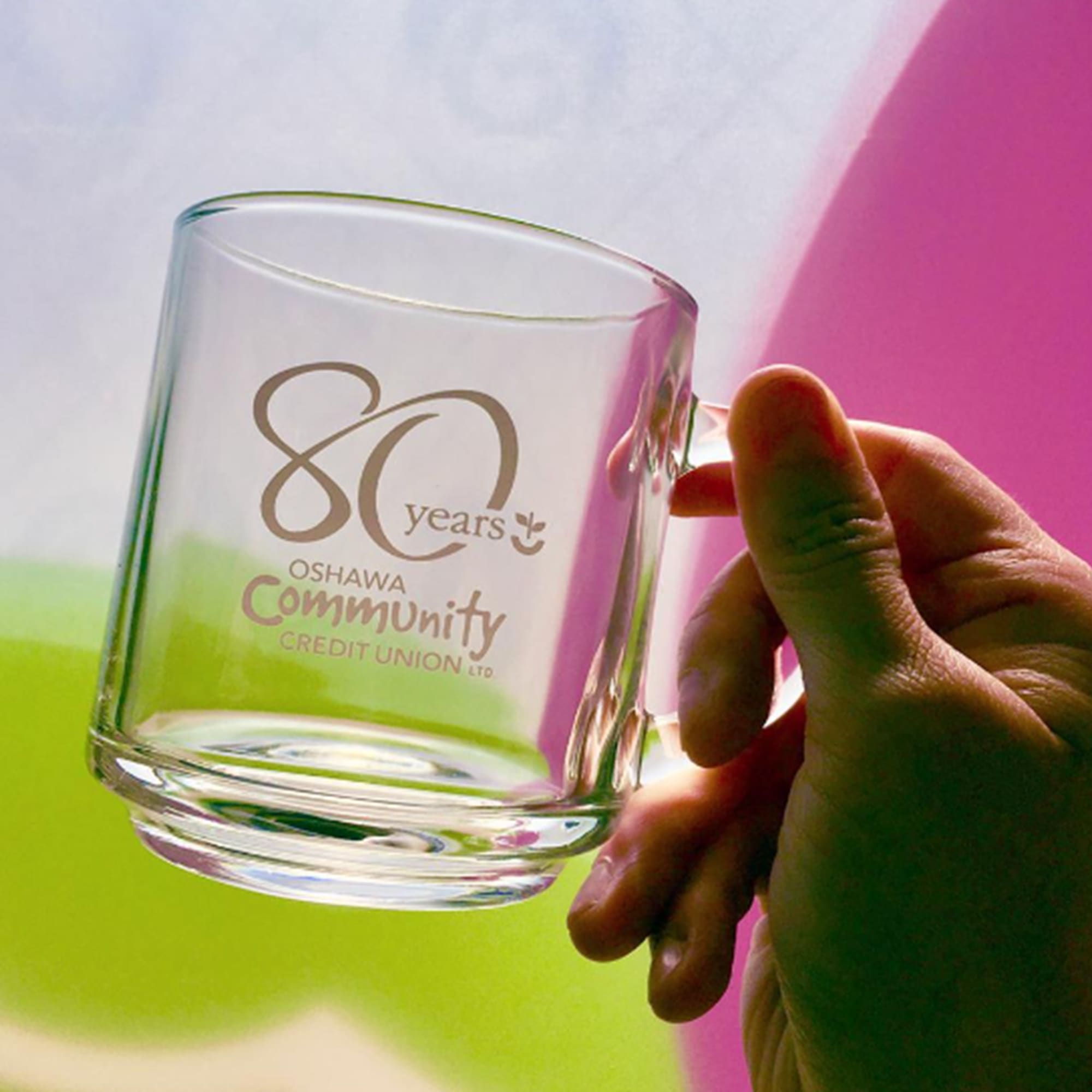 A glass mug with a transparent design and a handle, featuring a logo and decorative elements. Urban Classic Glass Mug 240ml - Image 1