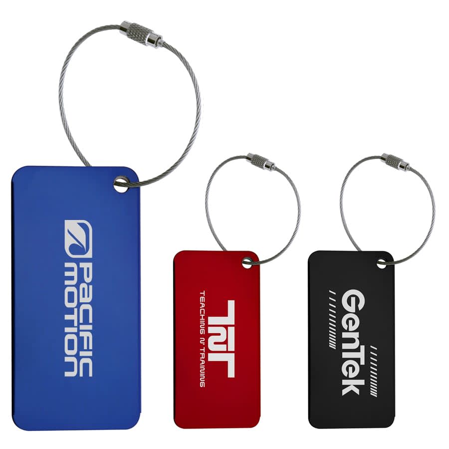 Three metallic luggage tags in blue, red, and black, each attached with a silver cable. All feature logos. Tremont Luggage Tag - Image 1
