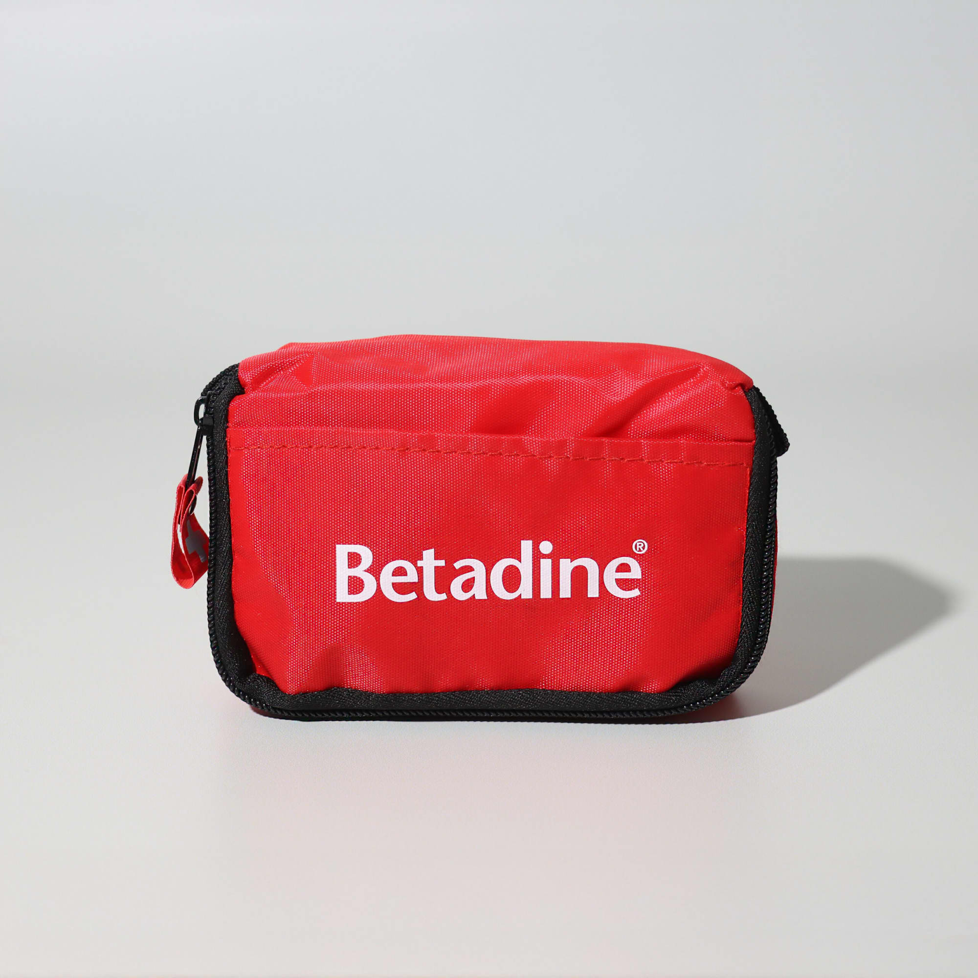 A red first aid travel kit with a zip closure and a logo on the front. Contains 13 essential first aid items. First Aid Travel Kit - 13 Piece - Image 1