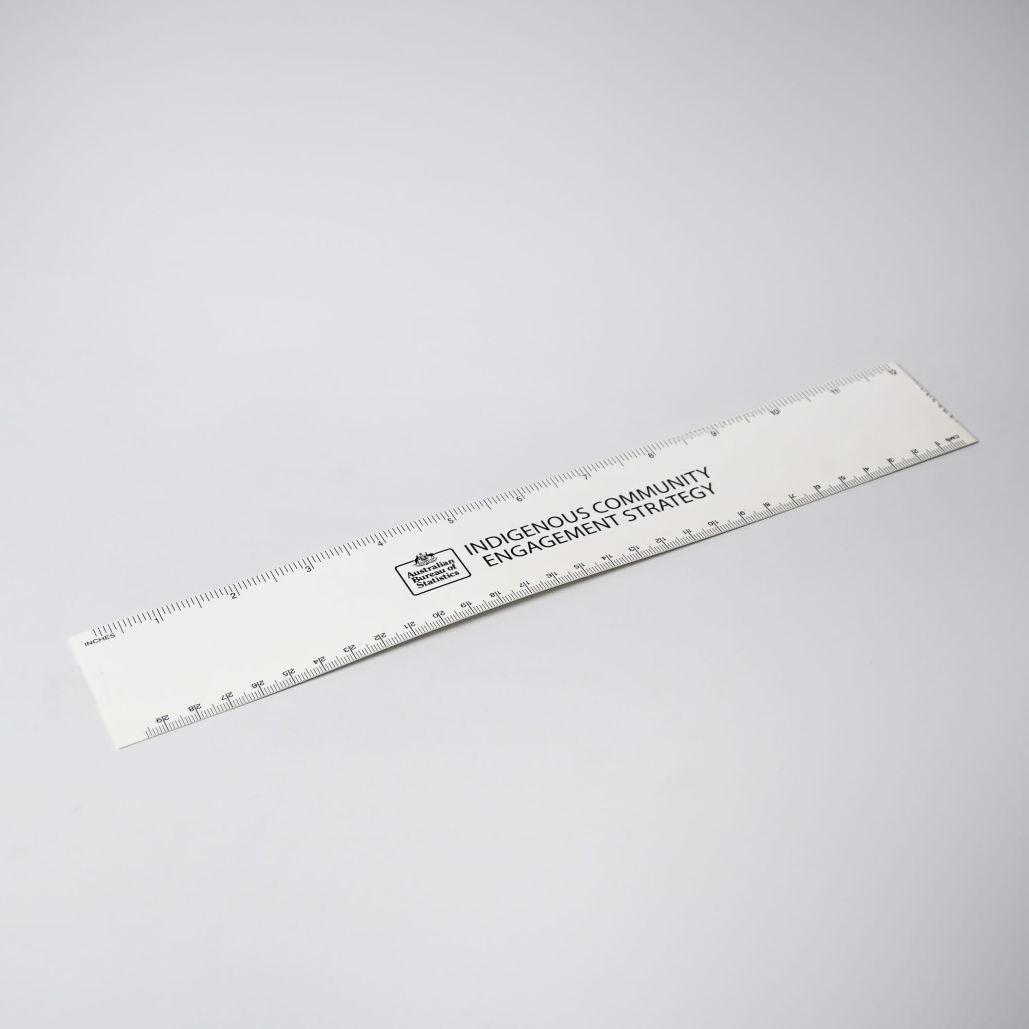 A white ruler with markings and a logo, designed for office and business use. Rulers - Image 1
