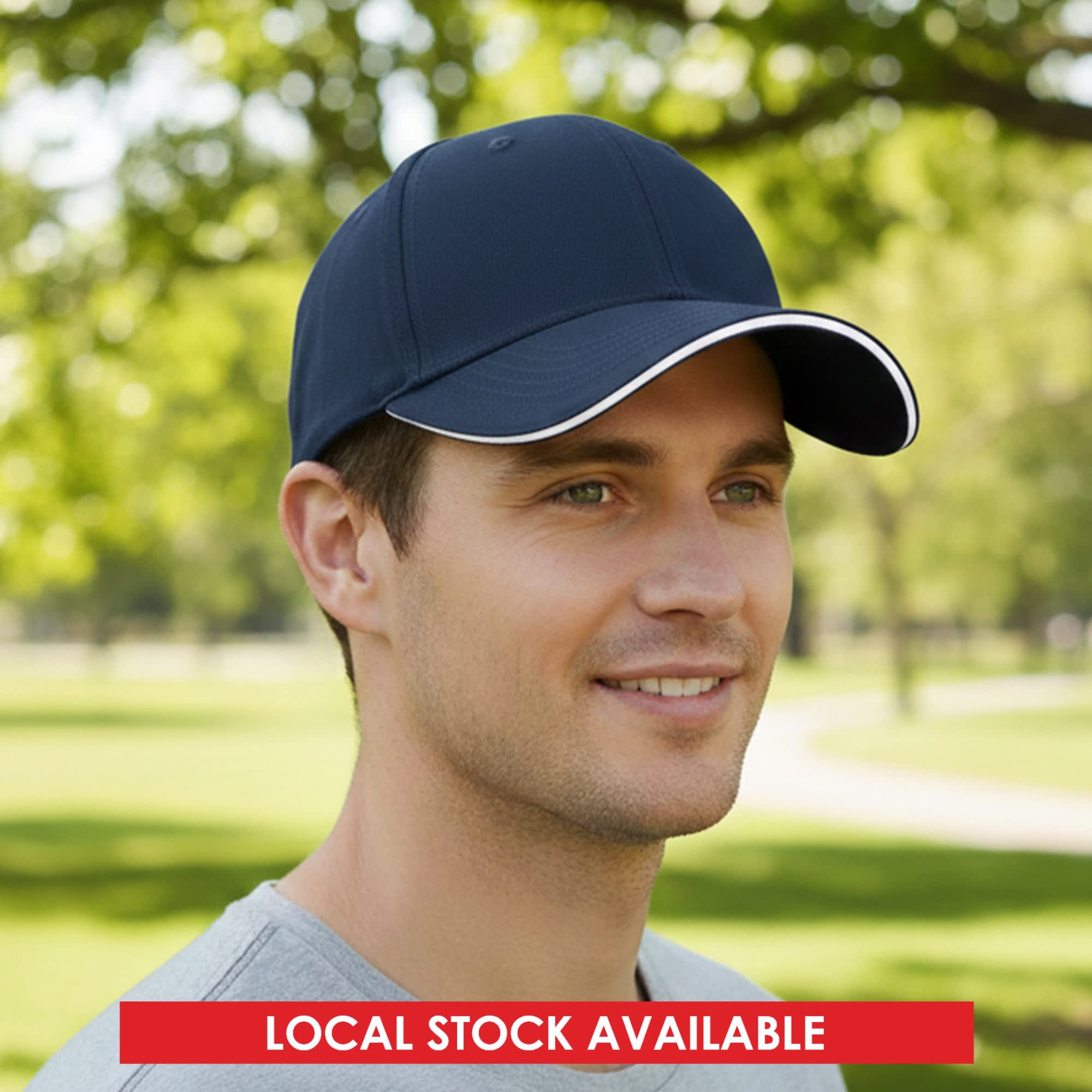 A navy blue cap with a white trim and a logo, set against a natural, green outdoor background. Const 6 Panel Cotton Sandwich Cap - Image 1