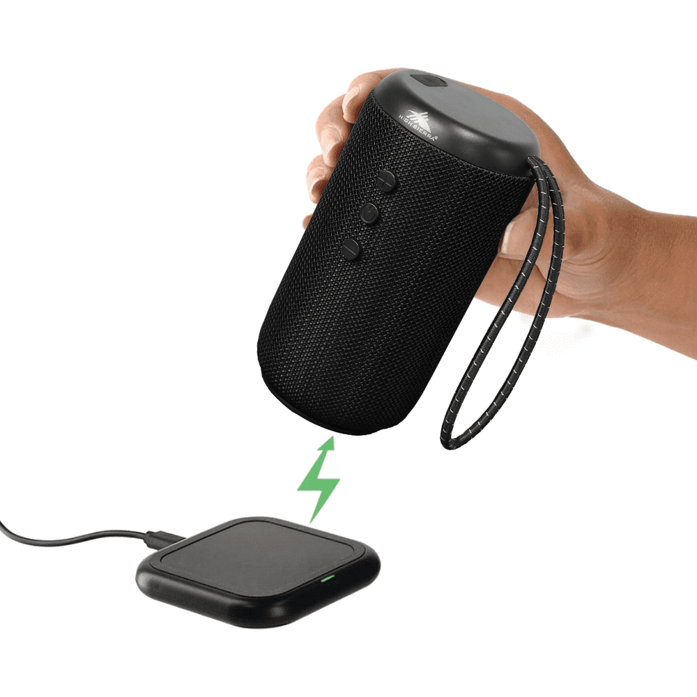 A black outdoor Bluetooth speaker held above a charging pad, featuring a textured finish and a carrying strap. High Sierra Kodiak IPX7 Outdoor Bluetooth Speaker - Image 1