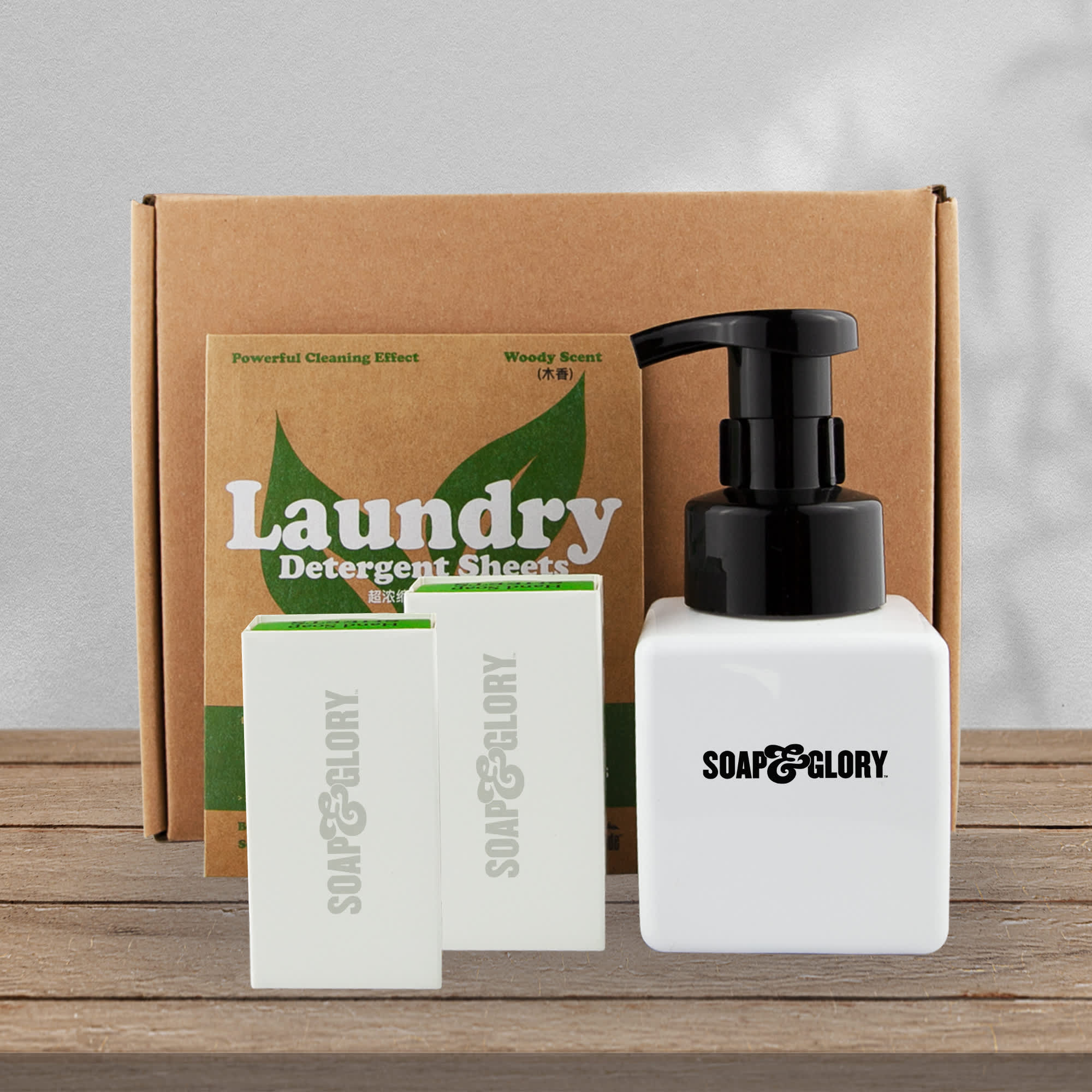 A white pump bottle with black lid beside three soap bars, placed in a brown box labelled "Laundry." Paper Soap and Bottle Gift Set - Image 1