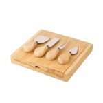 A bamboo cheese board set with four stainless steel cheese knives featuring wooden handles.
