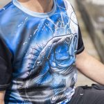 A men's fishing tee featuring a vibrant blue design with a large fish graphic and black sleeves.