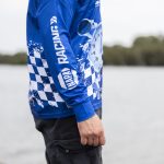 A blue long sleeve polyester fishing polo featuring a checkered design and a logo.
