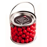 A medium PVC bucket filled with vibrant orange chocolate drops, featuring a handle and a logo on the lid.