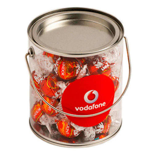 A big silver PVC bucket filled with red-wrapped Lindt chocolate balls, featuring a logo on the front. A big silver PVC bucket filled with red-wrapped Lindt chocolate balls, featuring a logo on the front.