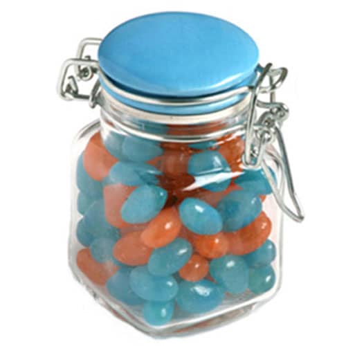A glass clip lock jar with a blue lid, filled with blue and orange mini jelly beans. Glass Clip Lock Jar with Mini Jelly Beans 80g - Image 1