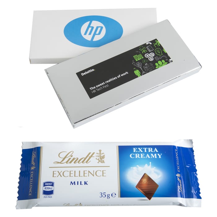 A silver box containing a 35g Lindt chocolate bar, labelled as Extra Creamy Milk, alongside a white box with a logo. Silver or White Box with Lindt Bar 35g - Image 1