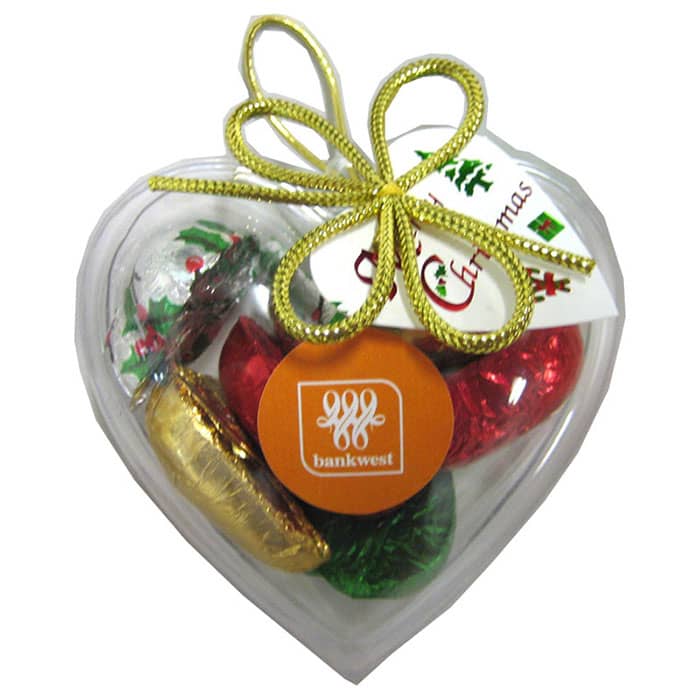 Acrylic heart-shaped container filled with assorted Christmas chocolates, featuring red, green, gold, and silver foiling. Acrylic Heart filled with Christmas Chocolates 65g - Image 1