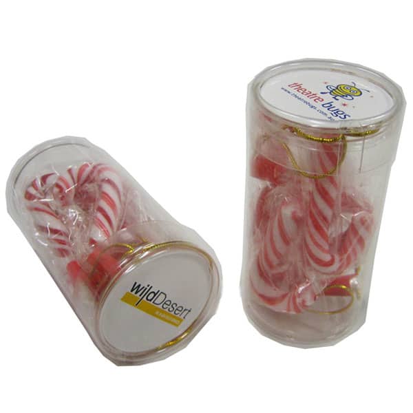 A clear tube containing six red and white candy canes, with a logo on the top. PET Tube filled with Candy Canes x6 - Image 1