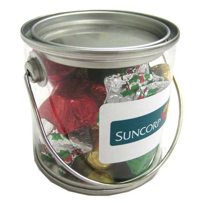 A small transparent PVC bucket filled with assorted Christmas chocolates in red, green, and gold wrappers. Small PVC Bucket with Christmas Chocolates 100g - Image 1