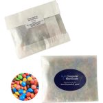 A kraft paper bag containing mixed M&Ms in various colours, featuring a logo on the packaging.
