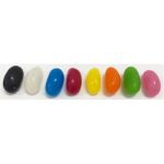 Jelly beans in various colours, including black, white, blue, red, yellow, green, orange, and pink, displayed in a row.