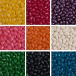 A collection of colourful jelly beans in various shades, arranged in a grid, featuring yellow, pink, orange, green, and more.