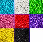A collection of choc beans in various colours, including blue, white, green, pink, red, purple, black, and yellow.