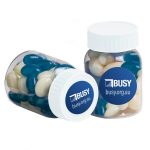 A baby jar filled with blue and white mini jelly beans, featuring a label with a logo.