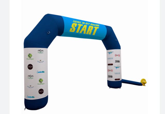 An inflatable air arch in blue and white with a start banner and multiple logos on the sides. Inflatable Air Arches 7m- Standard - Image 1