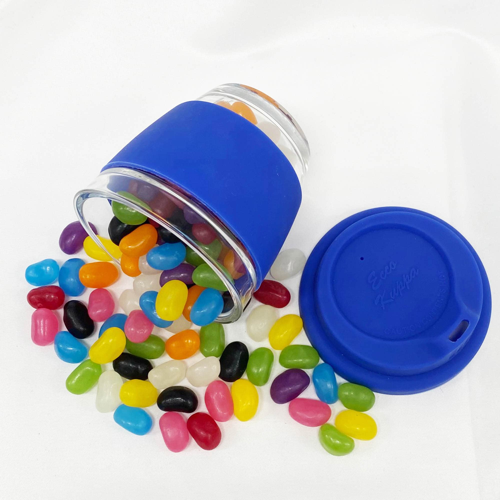 A blue reusable coffee cup made of glass, surrounded by colourful jelly beans and a matching lid. Jelly Bean In Venice Glass Coffee Cup - Image 1