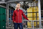 A red doubleface jacket with a zip, displayed on a model in a warehouse setting with storage units in the background.