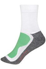 A pair of sports socks featuring a white upper, grey heel, and green cushioning. The design includes a logo.