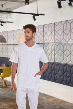 A man wearing a white men's stretch casack with short sleeves and pockets, standing in a modern space.