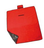 A red picnic blanket with a black edge and a small pocket. It features a branded logo.