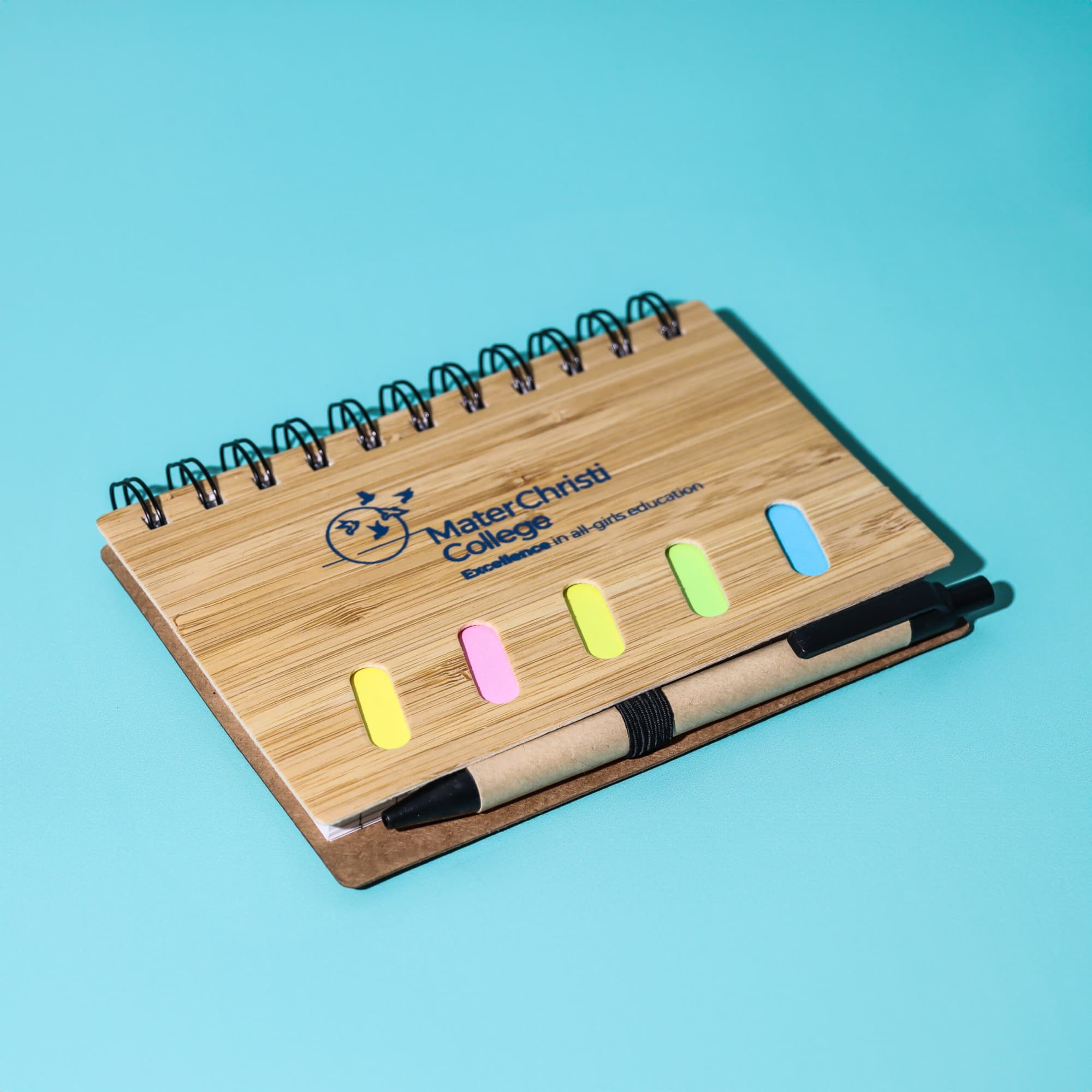 A bamboo notebook with a pen, featuring a spiral binding and multicoloured sticky tabs on the cover. Bamboo Notebook with Pen - Image 1