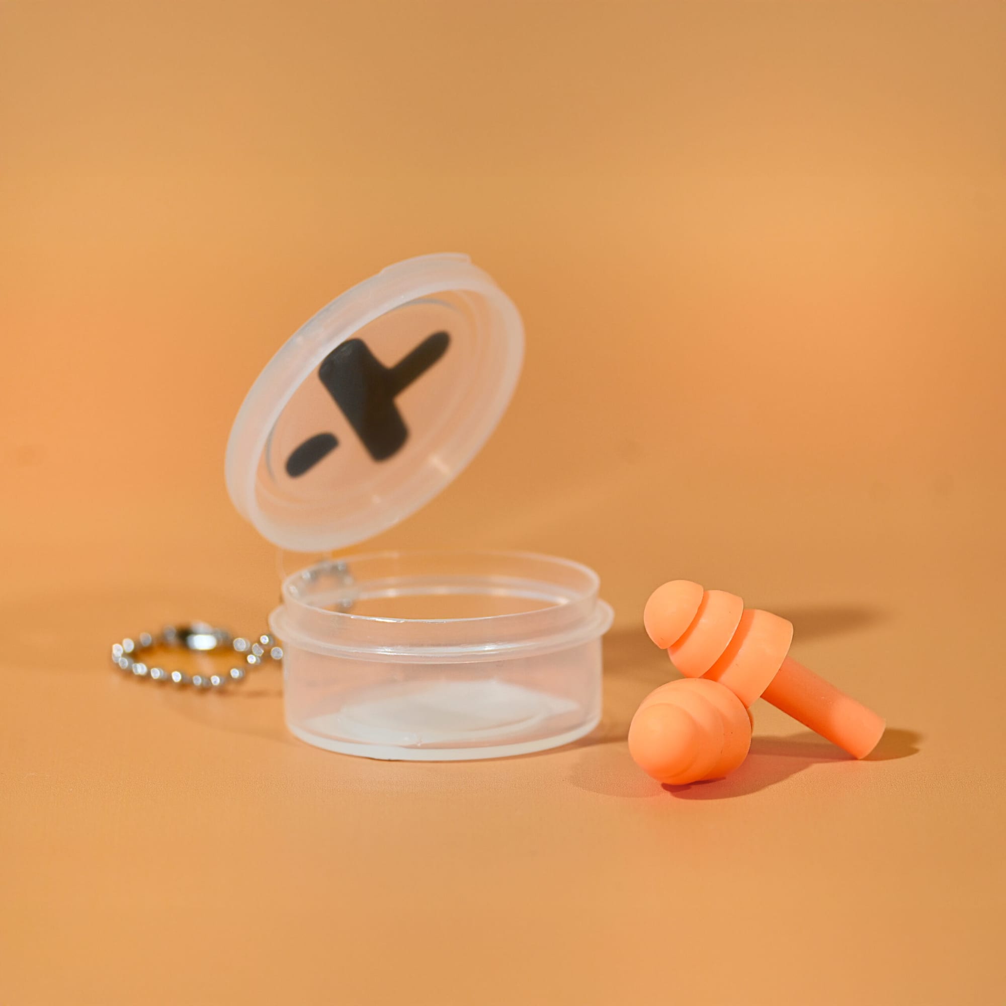An orange silicone earplug set in a clear case with a keychain attachment. The case lid is open. Silicone Earplug Keychain - Image 1
