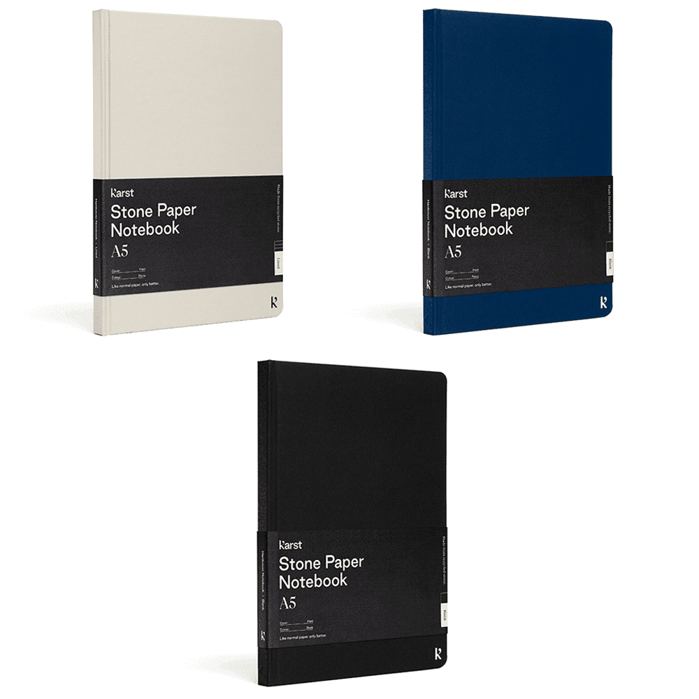 A set of three Karst A5 Stone Paper Hardcover Notebooks in cream, navy blue, and black, featuring a branding label. Karst A5 Stone Paper Hardcover Notebook - Image 1