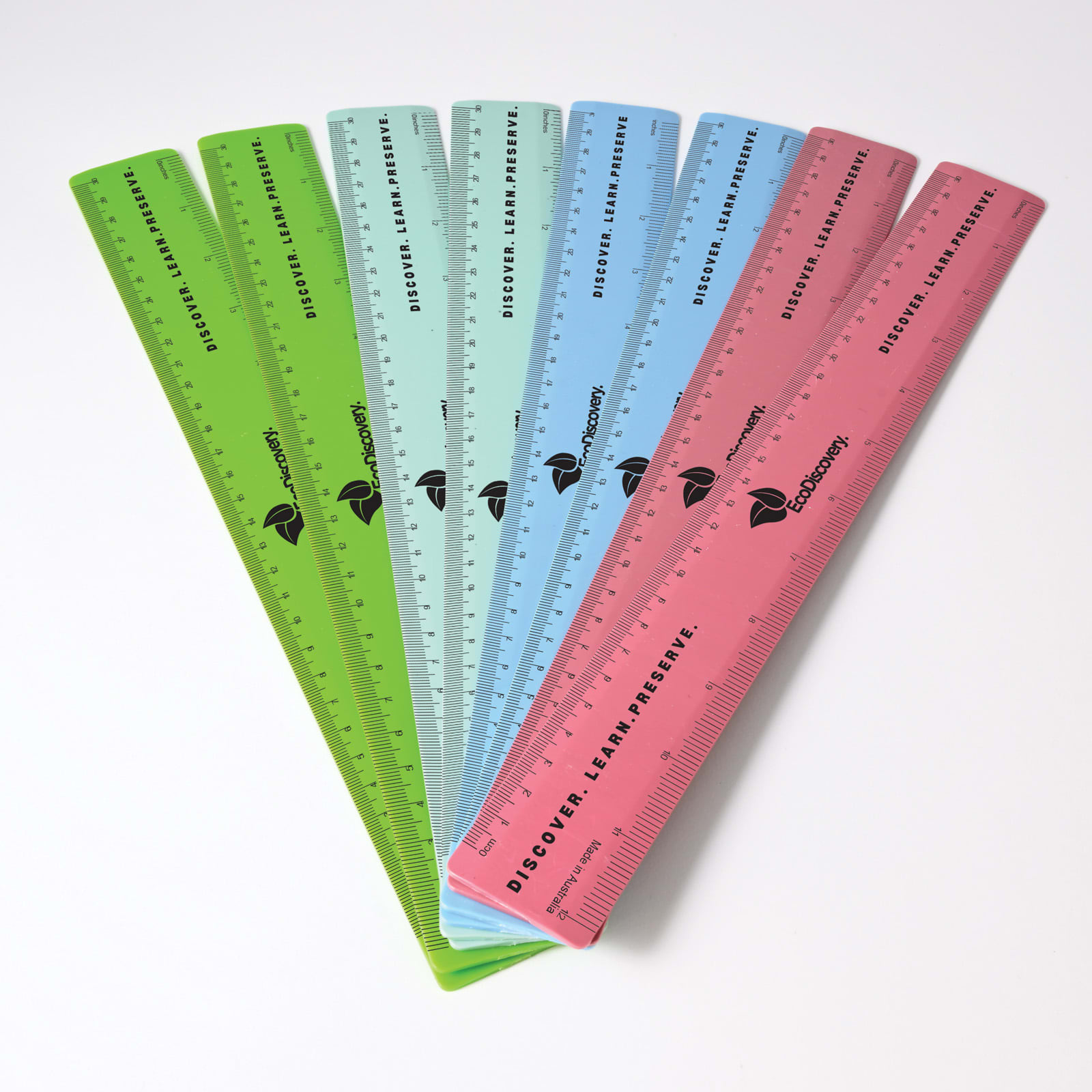 A collection of recycled plastic rulers in green, blue, and pink, featuring a logo and measurement markings. Recycled Plastic Ruler 30cm - Image 1