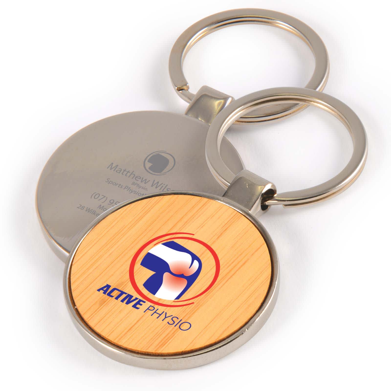 A round keytag with a bamboo front and a silver back, featuring a logo and keyring attachment. Circle Bamboo Zinc Keytag - Image 1