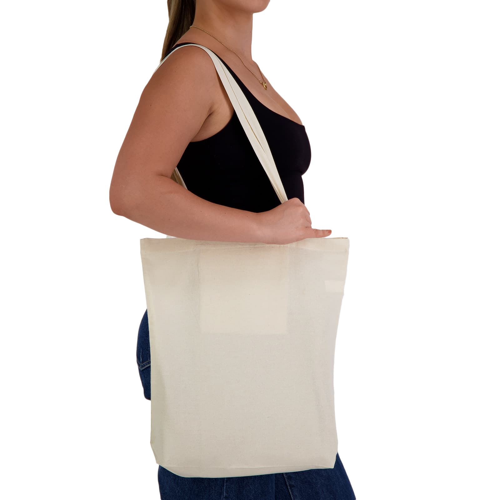 A cream-coloured tote bag is held by a person, featuring long straps and a simple design. It has a logo. City Shopper Folding Calico Bag (LH) - Image 1