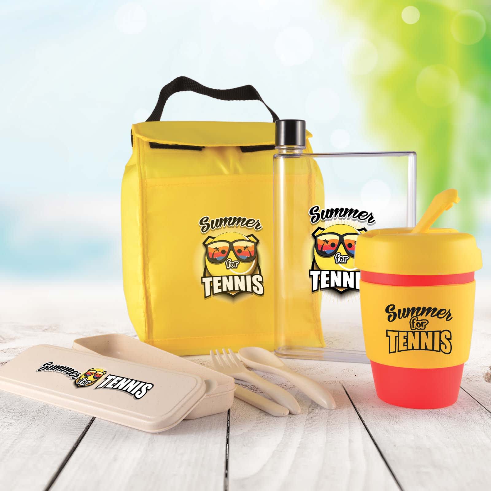 A yellow picnic set including a drink bottle, food container, cutlery, and a colorful cup, all featuring a logo. Picnic Pack - Image 1