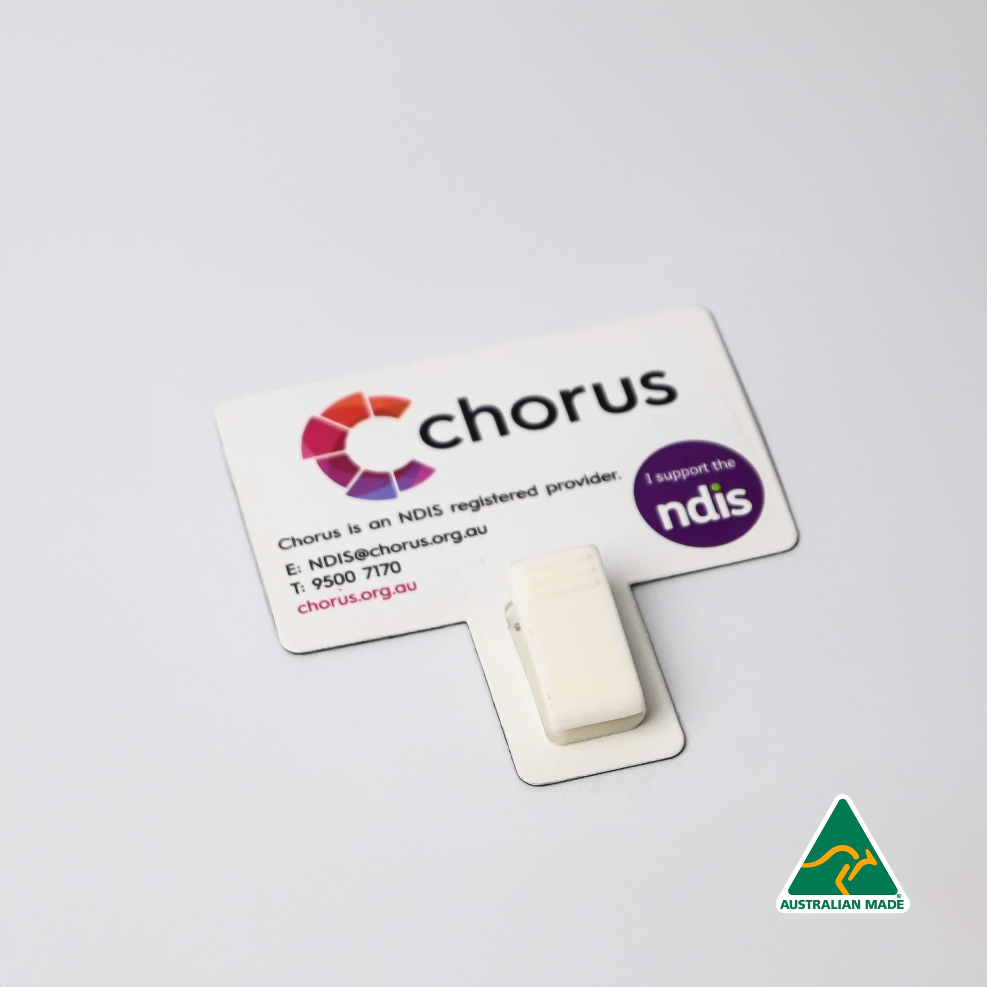 A white T-Magnet with a clip, attached to a printed card featuring logos and contact details. T-Magnet with Clip - Image 1