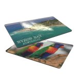 Double-sided magnet featuring colourful images of a beach scene and rainbow lorikeets, predominantly green, blue, and red.