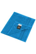A blue guest towel with a textured surface and striped detail, featuring a brand label.