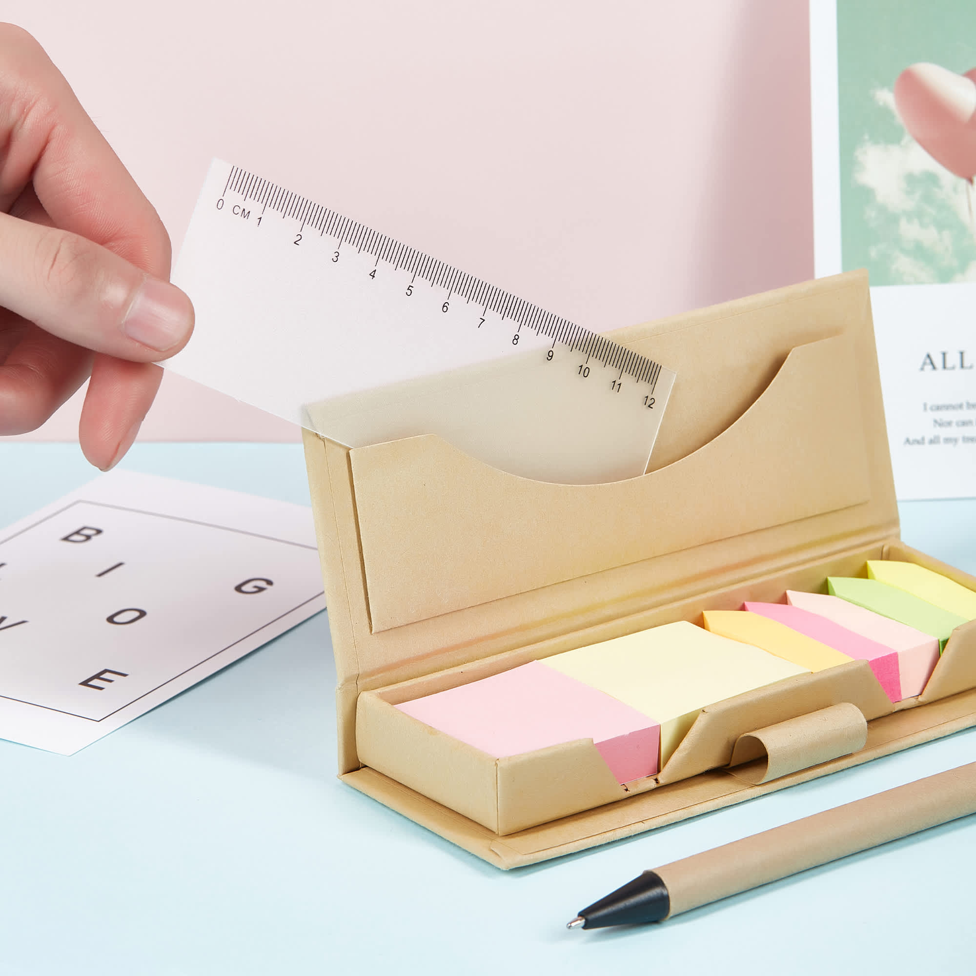 A memo holder with assorted sticky notes in pink, yellow, and green, featuring a ruler and a pen. Karno Memo Holder - Image 1