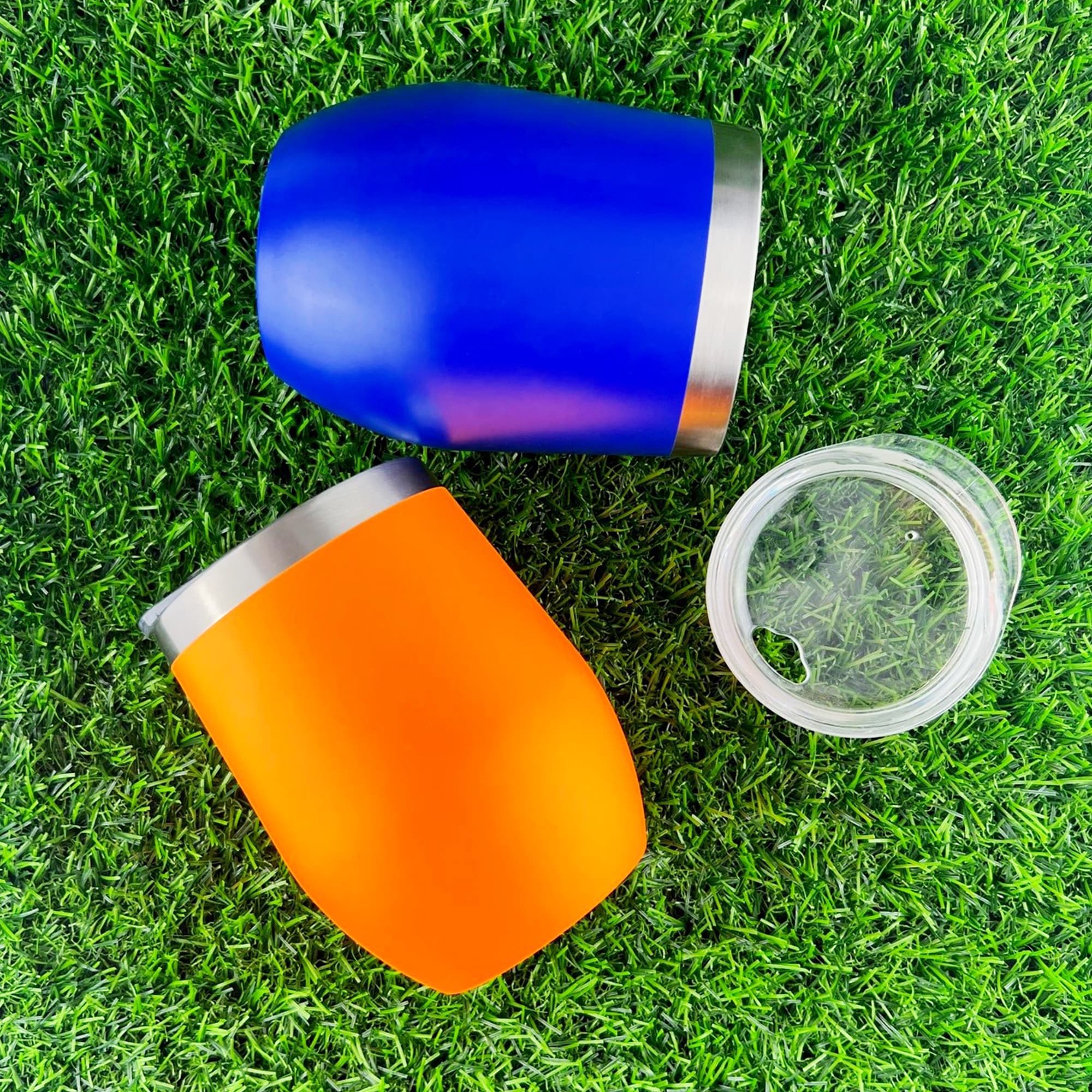 A drink bottle set featuring a blue and an orange travel mug with stainless steel accents, resting on green grass. Wine and Coffee Cup - Image 1