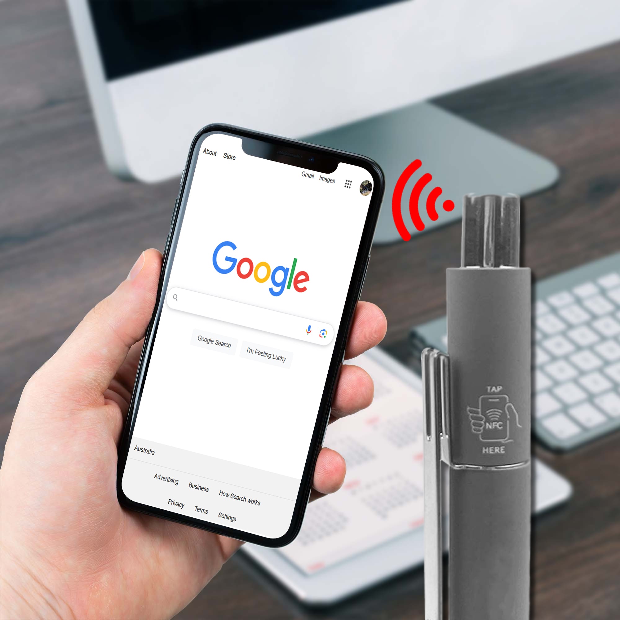 A grey metal pen with an NFC feature, placed beside a smartphone displaying a web search. NFC Touchview Metal Pen - Image 1